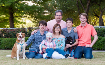 Hawes Family Photo - Mom, Dad, four sons, and a dog sitting outside and smiling. Both parents wearing glasses.